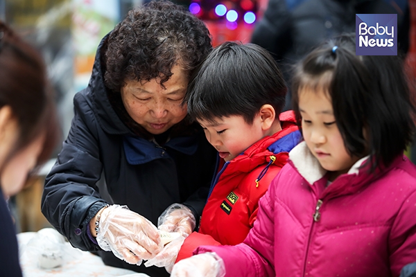 한 아이가 할머니의 도움을 받으면서 만두를 빚고 있다. 김재호 기자 ⓒ베이비뉴스