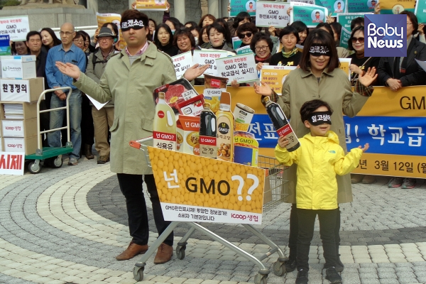 검정색 안대를 한 가족이 GMO 식품이 가득 담긴 쇼핑카트를 끌고 나와 퍼포먼스를 진행했다. 최규화 기자 ©베이비뉴스
