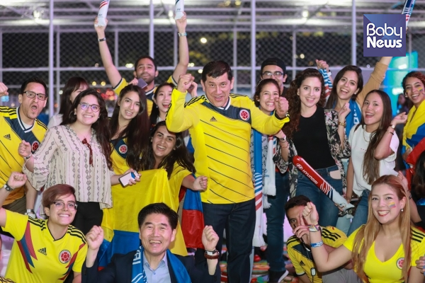 19일 저녁 후안 파블로 로드리게스 주한 콜롬비아 대사(맨 가운데 노란색 유니폼)가 현대자동차 팬파크 그라운드 글로벌 응원전을 찾은 자국민들과 함께 콜롬비아의 선전을 기원하고 있다. 최대성 기자 ⓒ베이비뉴스