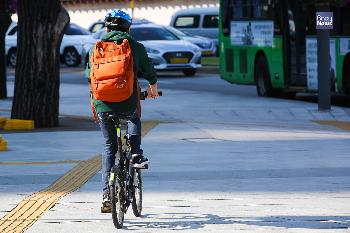 지난달 28일부터 시행된 자전거 헬멧 의무 착용에 대해 반감이 좀처럼 수그러들지 않고 있는 가운데 한 시민이 헬멧을 쓰고 자전거를 타고 있다. 김재호 기자 ⓒ베이비뉴스