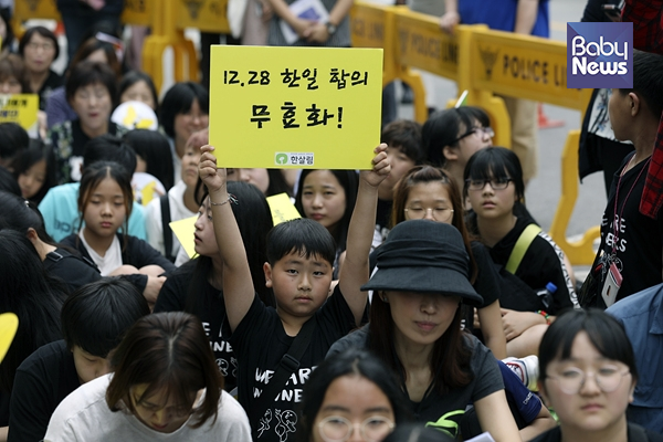 제 1392차 정기 수요시위에 참가한 어린이가 피켓을 높게 들고 있다. 김근현 기자 ⓒ베이비뉴스