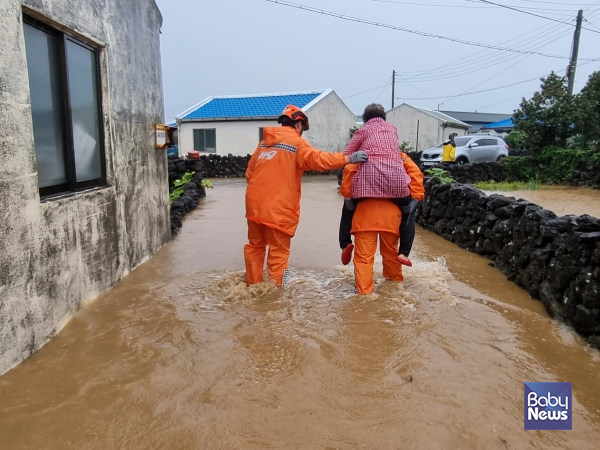 소방대원이 서귀포시 대정읍에서 폭우로 고립된 주민을 구출하고 있다. ⓒ제주소방안전본부