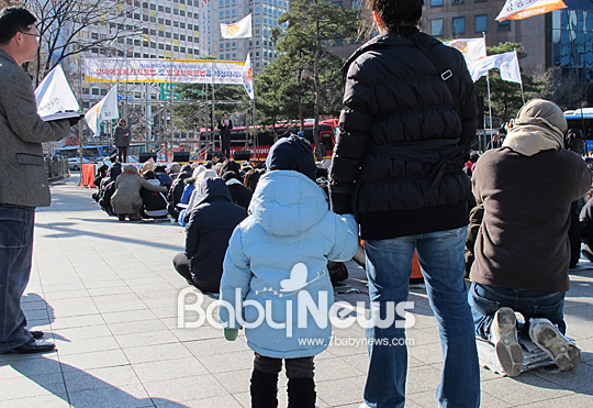 베이비뉴스 강석우 기자 = 한 장애아동의 부모가 아이와 함께 3일 오후 서울 종로구 보신각 앞 광장에서 열린 전국장애인부모권리선언대회 장면을 지켜보고 있다. sw.kang@ibabynews.com ⓒ베이비뉴스