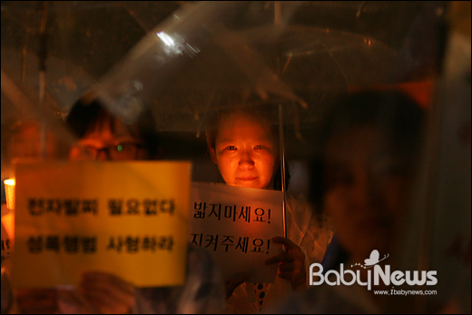 베이비뉴스 이기태 기자 = 아동성폭력 추방을 위한 시민모임 네이버 카페 '발자국' 회원인 아이 엄마들이 4일 저녁 서울시 중구 봉래동 서울역 광장에서 아동성범죄 규탄과 정부 대책 마련을 촉구하는 촛불집회를 갖고 있는 가운데 한 엄마가 '밟지마세요', '지켜주세요'라는 손팻말을 든 채 눈물을 흘리고 있다. likitae@ibabynews.com ⓒ베이비뉴스