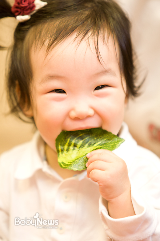 한 아기가 나뭇잎을 입에 물고 해맑은 미소를 짓고 있습니다. 이기태 기자 likitae@ibabynews.com ⓒ베이비뉴스