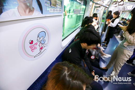 지하철 1호선 열차 안 임신부 배려석에 앉은 중년여성. 임산부 배지를 가방에 단 임신부는 자리를 양보해 학생의 배려로 일반석에 앉았다. 최대성 기자 ⓒ베이비뉴스 