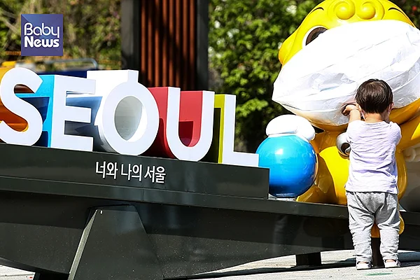 한 아이가 어린이대공원 해치 조형물에 씌워진 마스크가 신기한 듯 만져보고 있다. 서종민 기자 ⓒ베이비뉴스