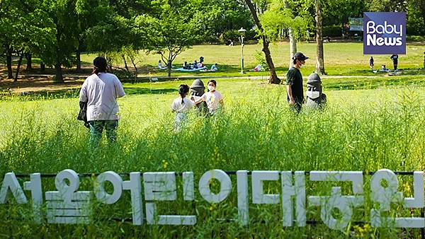 어린이대공원 유채꽃 화단에서 아이들이 가족들과 마스크가 씌워진 돌하르방을 구경하는 둥 즐거운 시간을 보내고 있다. 서종민 기자 ⓒ베이비뉴스