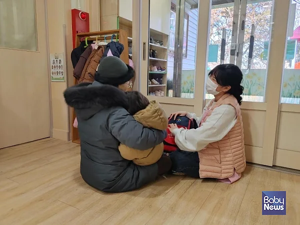 부모와 조부모가 교실 앞에서 하원하는 영아를 챙기고 교사와 소통하는 모습. ⓒ김영명
