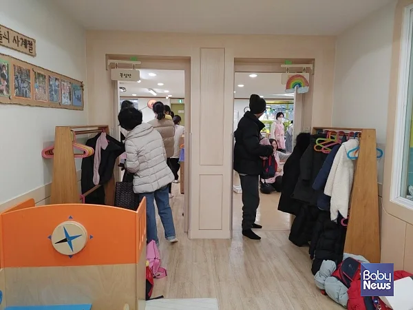 부모와 조부모가 교실 앞에서 하원하는 영아를 챙기고 교사와 소통하는 모습. ⓒ김영명