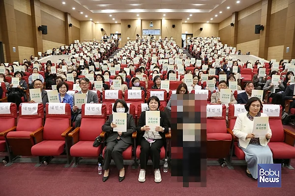 16일 오후 2시, 국회의원회관 대회의실에서 열린 ‘영유아 교육·보육 통합기관 설립 및 운영기준 방안 모색’ 유보통합 관련 연구용역 결과 설명회에서 참가자들이 '기존시설 유지안정'이라는 메시지가 적힌 자료집을 들고 기념촬영을 하고 있다. 소장섭 기자 ⓒ베이비뉴스