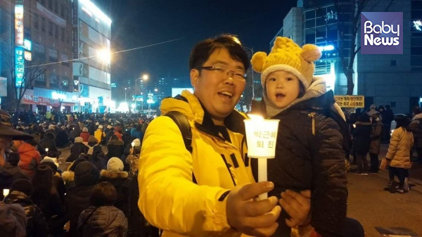 지난해 겨울, 딸과 촛불집회에 나갔던 윤민섭 예비후보. 어린이 안전 조례와 슈퍼우먼 방지 조례 등을 만들어 더 좋은 세상을 만들겠다는 약속을 지키싶은 아빠 후보다. ⓒ윤민섭
