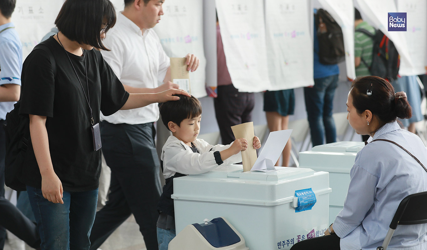 제7회 전국동시지방선거 사전투표 첫 날인 8일 오후 부모와 함께 서울역 남영동 사전투표소를 찾은 한 아이가 투표를  돕고 있다. 최대성 기자 ⓒ베이비뉴스
