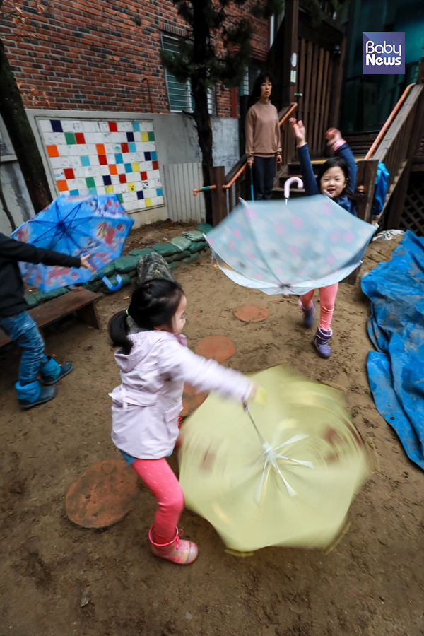 내리는 봄비에 춤추는 동심 - 비가 내리던 지난 15일 또바기 공동육아 어린이집 아이들이 마당에서 우산을 날리는 놀이를 하고 있다. 비가 내리면 우산 쓰기에 급급한 어른과는 너무나 다른 아이들 모습. 최대성 기자 ⓒ베이비뉴스