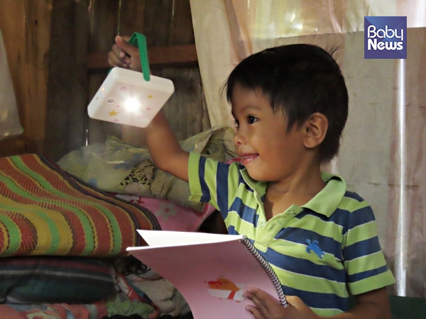 필리핀 세부의 빈민지역 아동이 선물받은 태양광랜턴과 학용품을 들어올리고 있다. ⓒ밀알복지재단