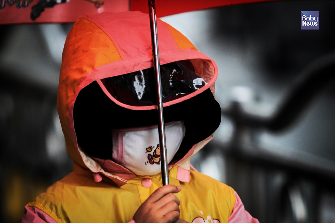 17일 오전 전국적으로 요란한 봄비가 내렸다. 한 아이가 비를 피하기 위한 우산, 우비에 마스크까지 쓰고 있다. 김재호 기자 ⓒ베이비뉴스