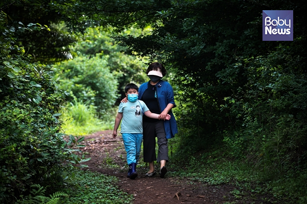 "선생님과 오름 산책." 제주도의 자연환경은 발달장애아동의 치료에 큰 도움이 된다. 선생님과 민오름을 산책하는 건하. 최대성 기자 ⓒ베이비뉴스