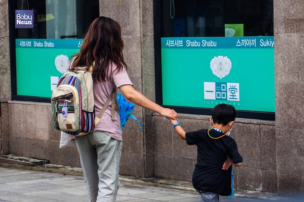 24일 오후 비가 소강상태로 접어든 광화문광장 일대에서 한 아이가 엄마의 손을 잡고 걸어가고 있다. 김재호 기자 ⓒ베이비뉴스