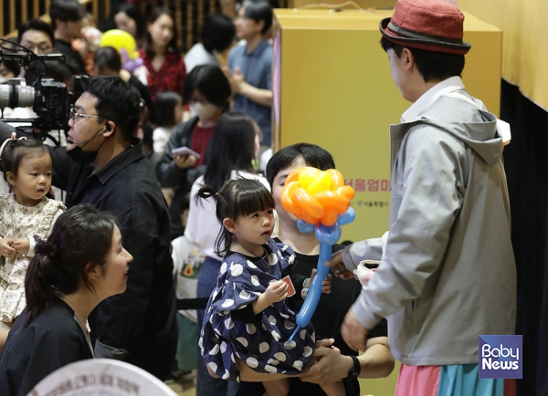 1회 서울엄마아빠 행복축제 참여마당에서 키다리 아저씨에게 풍선을 건네받고 있는 아이의 모습. 이효상 기자 ⓒ베이비뉴스