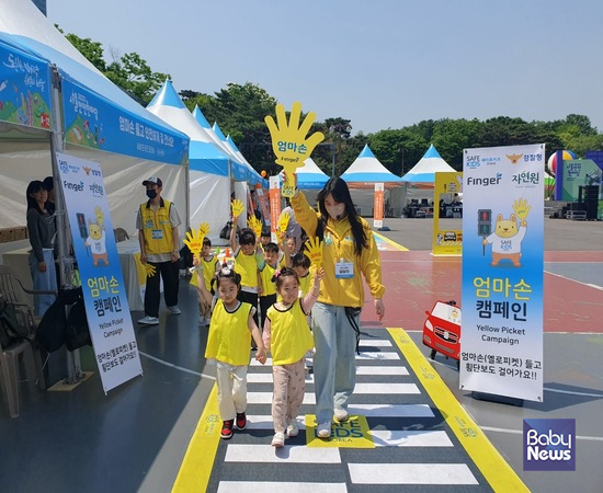 박성미 세이프키즈코리아 안전강사(오른쪽)가 13일 여의도공원 서울안전한마당에 참여한 어린이들에게 노란 엄마손피켓(옐로피켓)을 들고 안전하게 횡단보도 건너기 체험교육을 지도하는 모습. ⓒ세이프키즈코리아