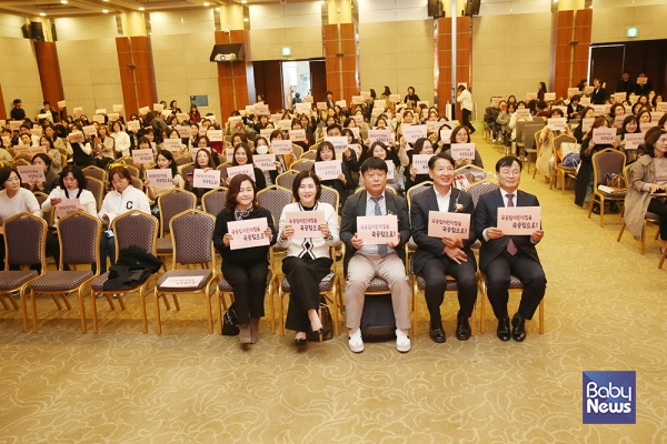 2024년도 제11회 전국국공립 보육인대회 참석자들이 "국공립어린이집을 국공립으로!" 슬로건이 적힌 자료집을 들고 기념촬영을 하고 있다. ⓒ전국국공립어린이집연합회