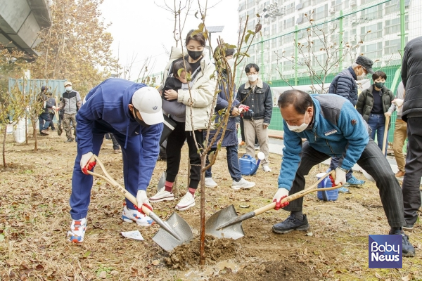 민선 7기 ‘500만 그루 나무심기’ 행사에 참여한 유동균 마포구청장과 주민들이 함께 나무를 심고 있다.