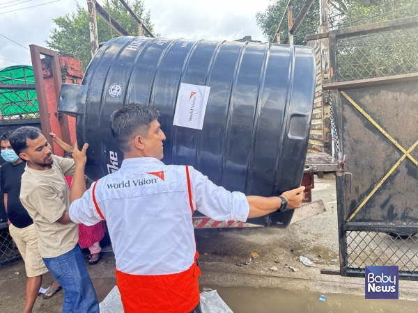 비두르시 제1구역에 다목적 물탱크 50개와 고밀도 폴리에틸렌(HDPE) 배관을 전달하고 있는 월드비전 직원 모습. (사진 월드비전 제공)